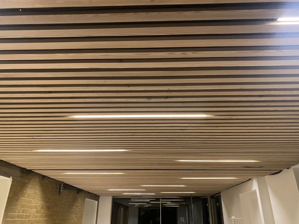 Bello Electrics Ltd, Slatted timber ceiling with recessed linear LED lighting in a commercial interior